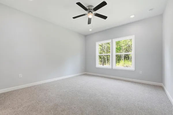 an empty room with a window and a ceiling fan