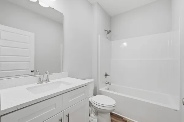 a bathroom with a sink toilet vanity and bathtub