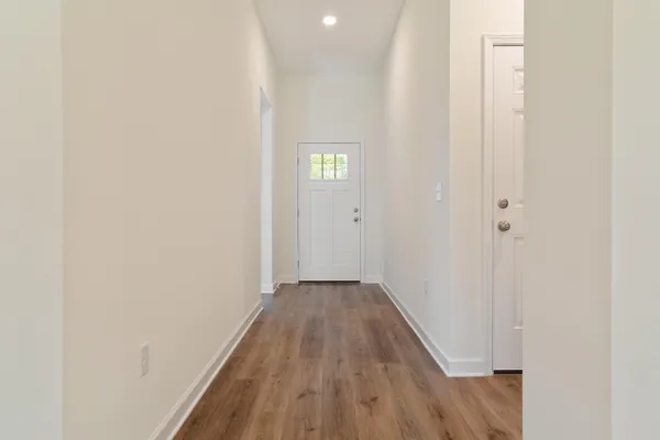 a view of a hallway with wooden floor