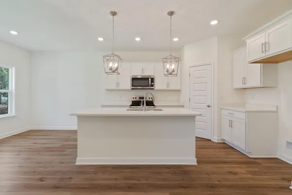 a kitchen with kitchen island a sink stainless steel appliances and cabinets