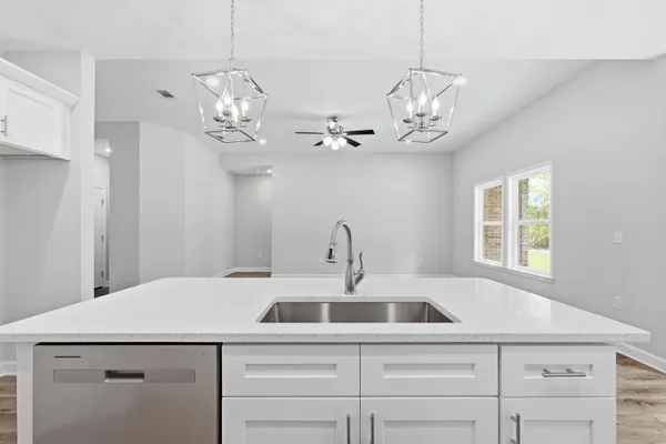 a kitchen that has a lot of cabinets and a wooden floor
