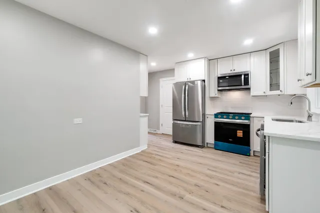a kitchen with stainless steel appliances a refrigerator and a stove top oven