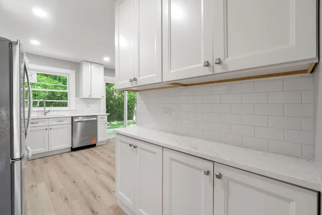a kitchen with granite countertop white cabinets and white appliances