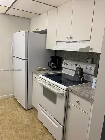a kitchen with stainless steel appliances white cabinets and a refrigerator