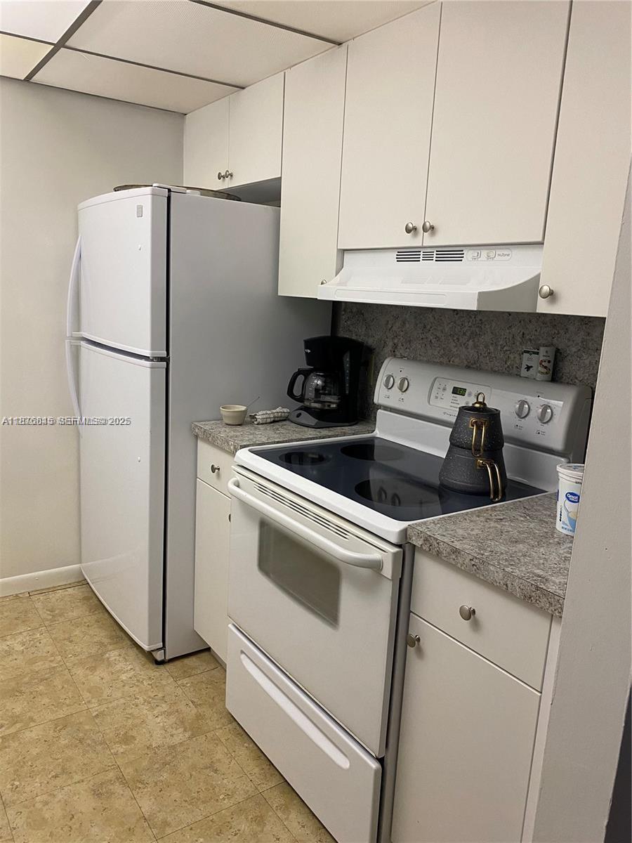 a kitchen with stainless steel appliances white cabinets and a refrigerator