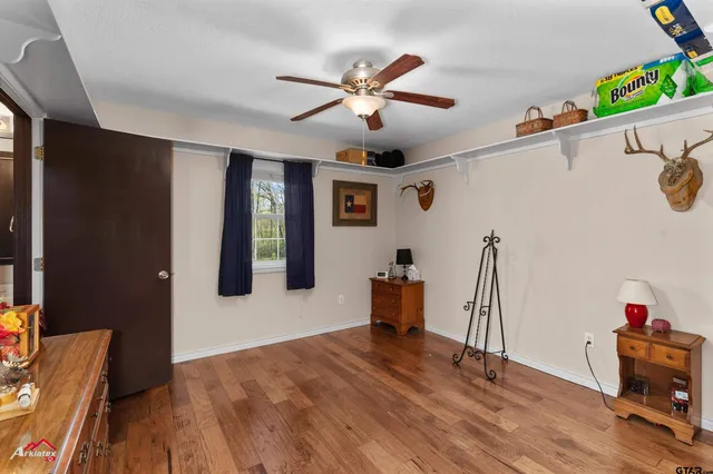 a view of a livingroom with wooden floor and a ceiling fan