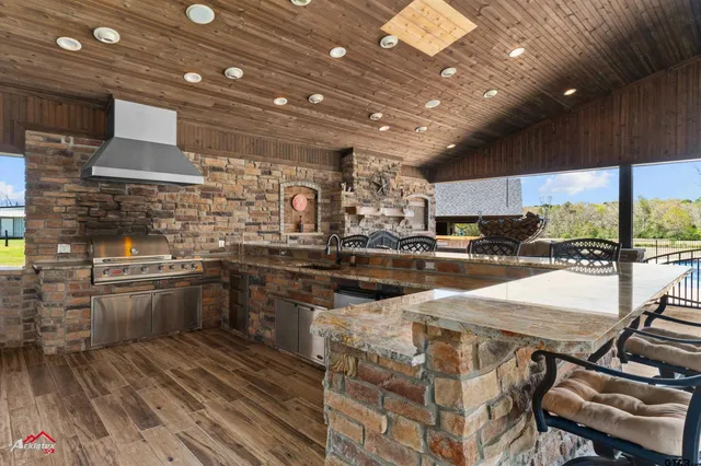 a kitchen with stainless steel appliances granite countertop a sink and a stove