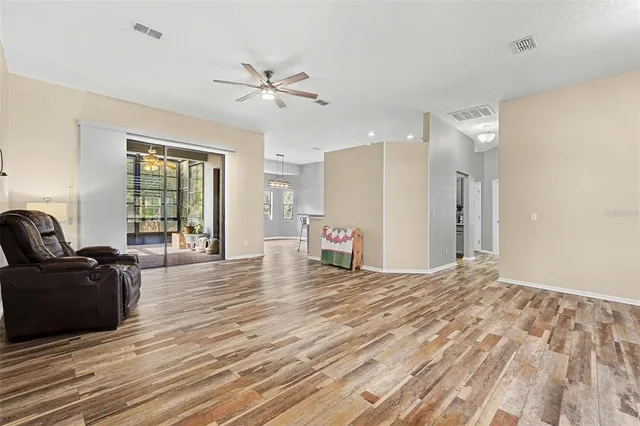 a view of a livingroom with wooden floor and a ceiling fan