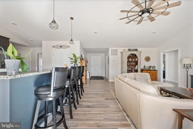 a kitchen with a dining table chairs stainless steel appliances and cabinets