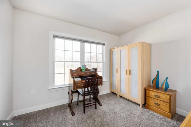 a spacious bedroom with a bed and a book shelf