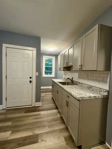 a large kitchen with granite countertop a sink and cabinets