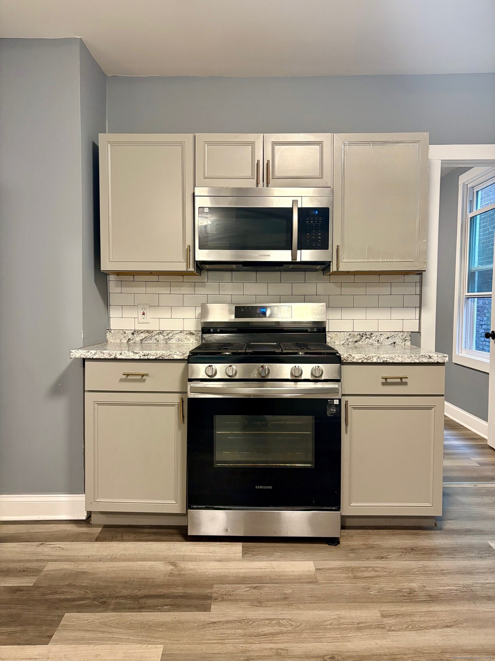8 Read Street New Haven, CT 06511 - Photo 16 of 21 a kitchen with stainless steel appliances a stove a microwave and white cabinets