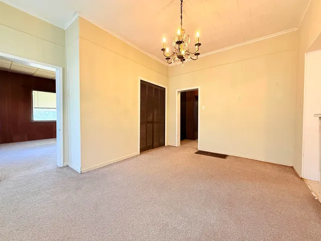 a view of a livingroom with a chandelier fan and windows