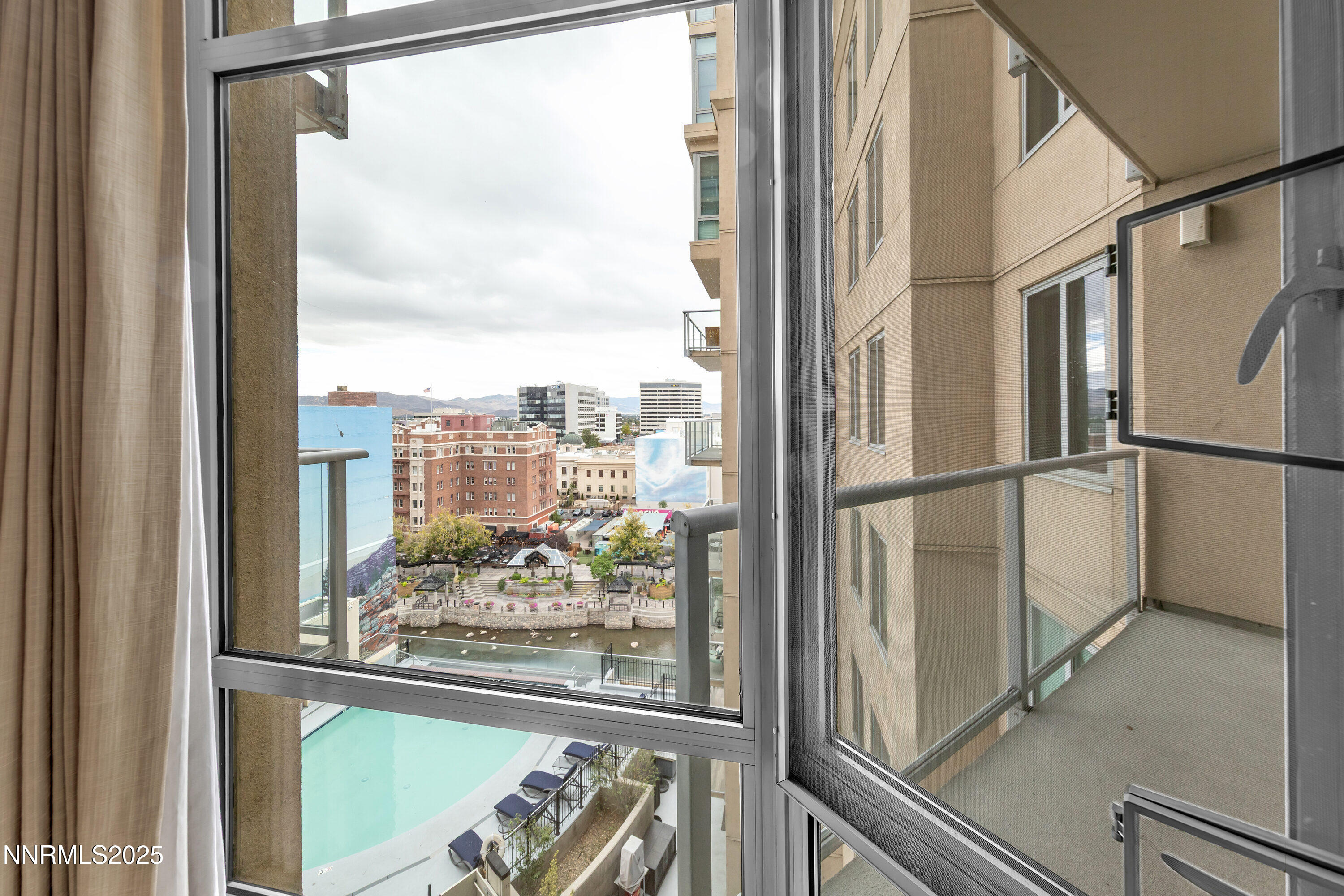 a view of a glass door with a balcony from a window
