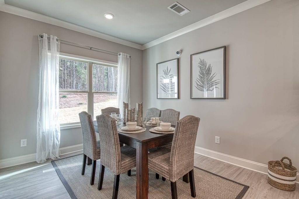 663 Secret Garden Lane Dacula, GA 30019 - Photo 12 of 27 a dining room with furniture a rug and wooden floor