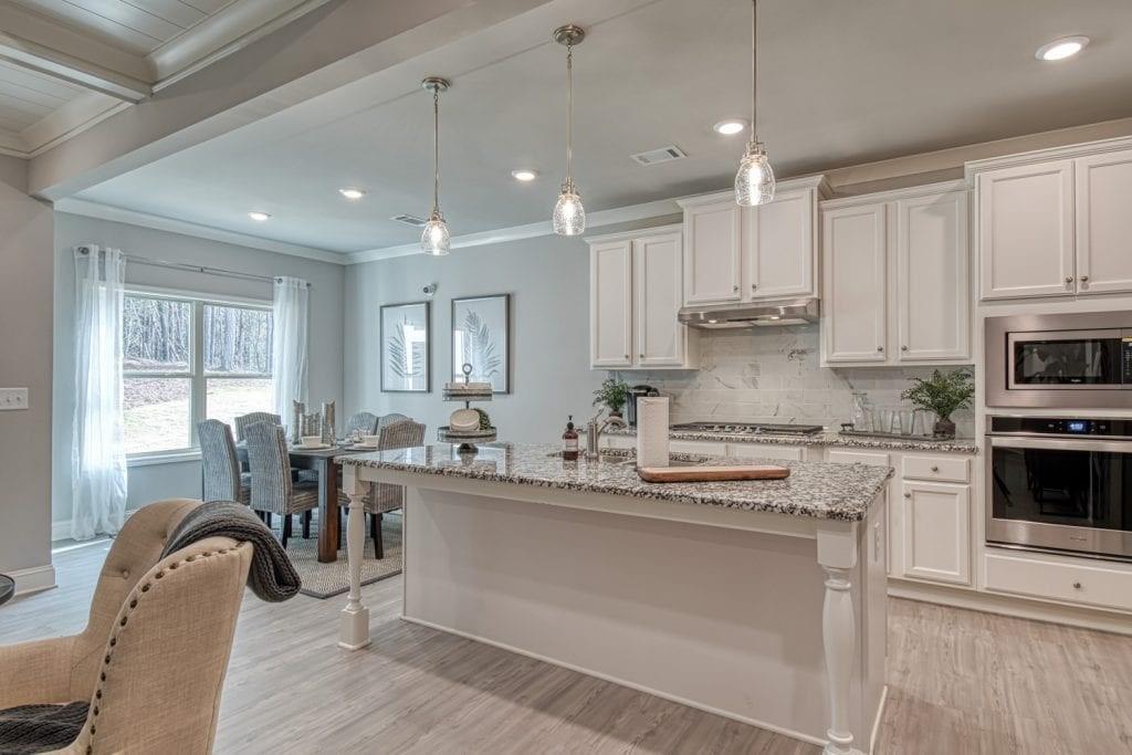 663 Secret Garden Lane Dacula, GA 30019 - Photo 18 of 27 a kitchen with kitchen island granite countertop a sink cabinets and stainless steel appliances