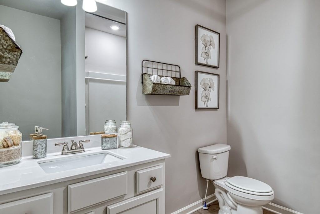 663 Secret Garden Lane Dacula, GA 30019 - Photo 8 of 27 a bathroom with a toilet a sink and mirror