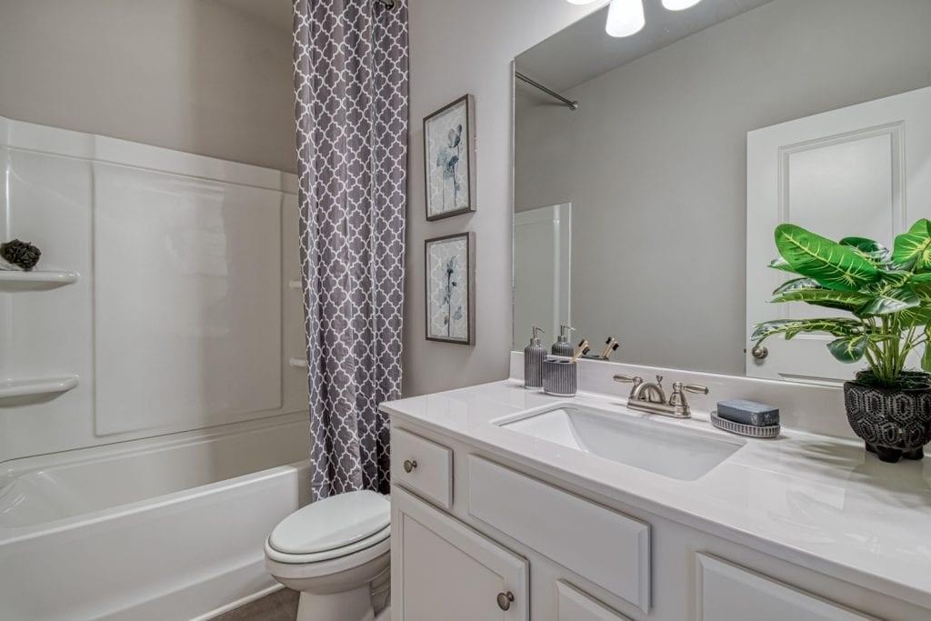 663 Secret Garden Lane Dacula, GA 30019 - Photo 9 of 27 a bathroom with a sink a toilet a tub and shower