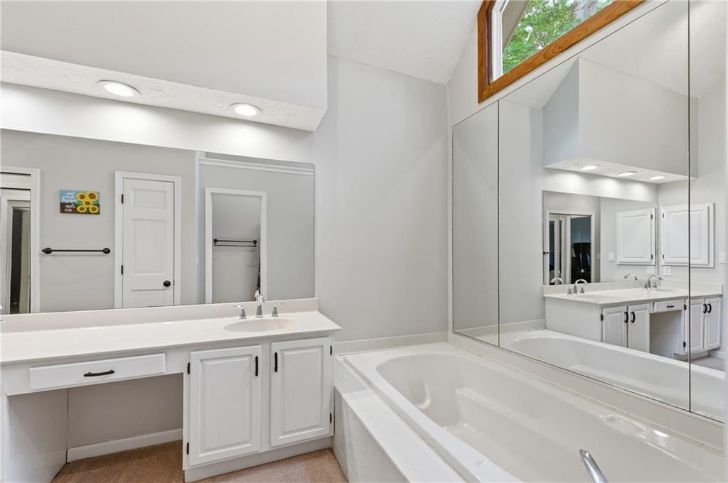 1925 Crescent Ridge Cumming, GA 30041 - Photo 31 of 36 a bathroom with a bathtub a double vanity sink and mirror