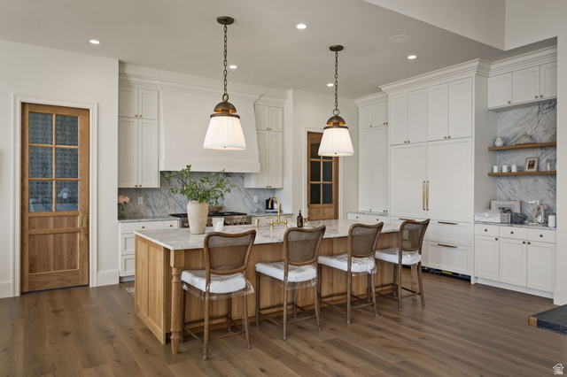 478 South Maple Lakes Drive Mapleton, UT 84664 - Photo 8 of 51 Gourmet kitchen featuring a wood-finish island with seating, integrated paneled appliances, marble countertops and backsplash, white cabinetry, and wood-finish flooring