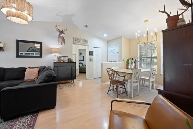 a living room with furniture wooden floor and a chandelier