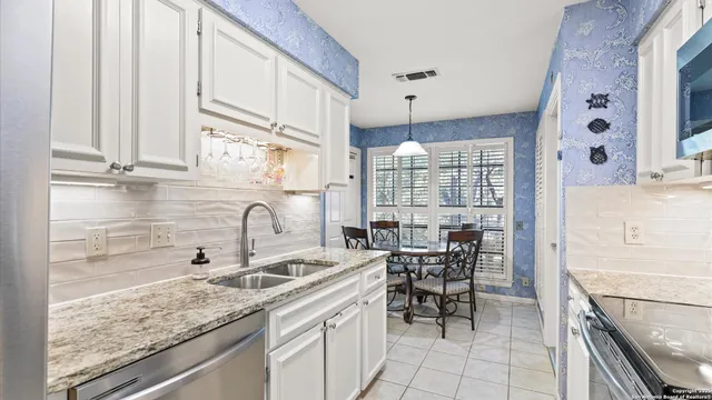 a kitchen with stainless steel appliances granite countertop a sink and a stove