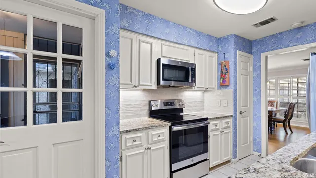 a kitchen with stainless steel appliances granite countertop a stove and a microwave