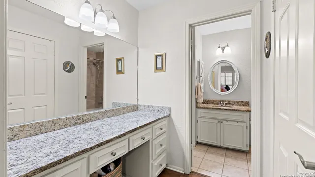 a bathroom with a granite countertop sink a mirror and a vanity