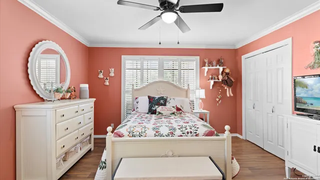 a view of a bedroom with a bed and wooden floor
