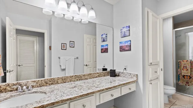 a bathroom with a granite countertop sink and a mirror