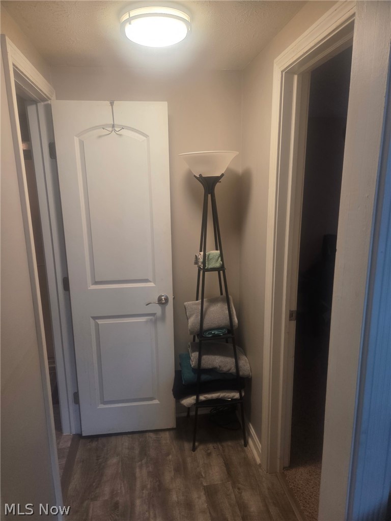 4422 Rodgers Road Ashtabula, OH 44004 - Photo 7 of 11 Corridor with dark wood-type flooring and a textured ceiling