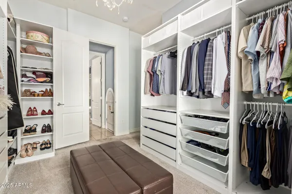 a view of walk in closet with clothes and shoes