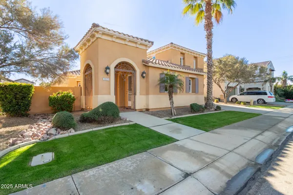 a front view of a house with a garden and plants