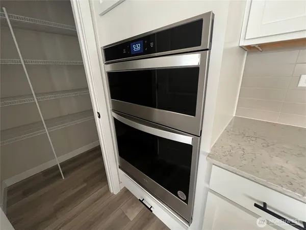 a kitchen with stainless steel appliances granite countertop a stove a sink and white cabinets