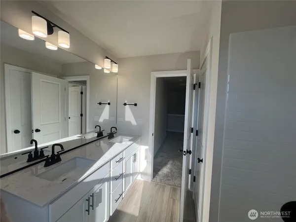 a view of hallway with a bed and wooden floor