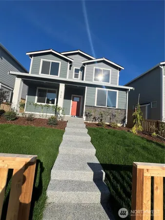 a front view of a house with a yard and potted plants