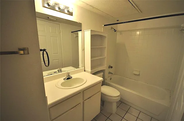 a bathroom with a granite countertop sink a toilet and shower
