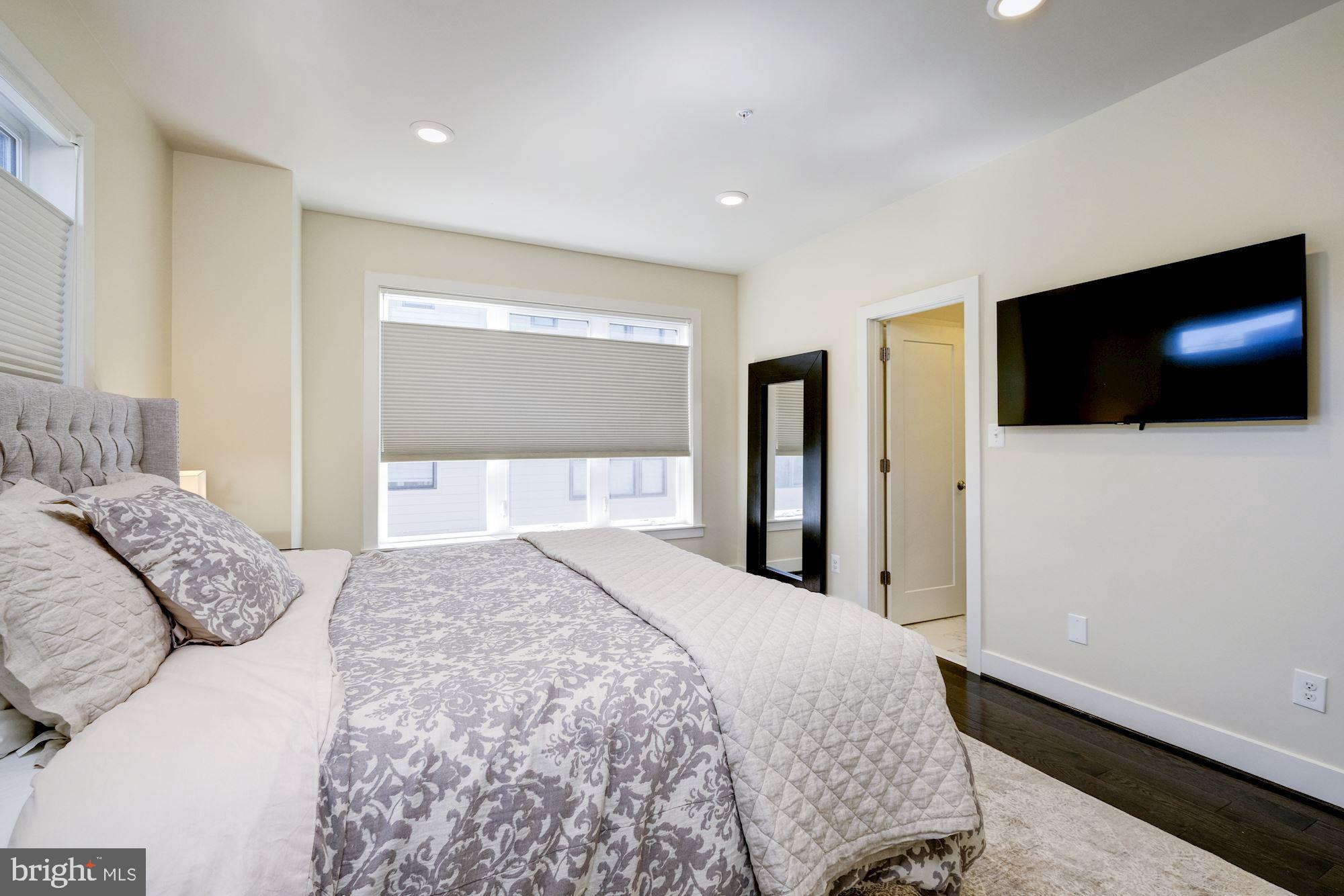 6640 Eames Way Bethesda, MD 20817 - Photo 19 of 38 a bedroom with a large bed and a flat screen tv
