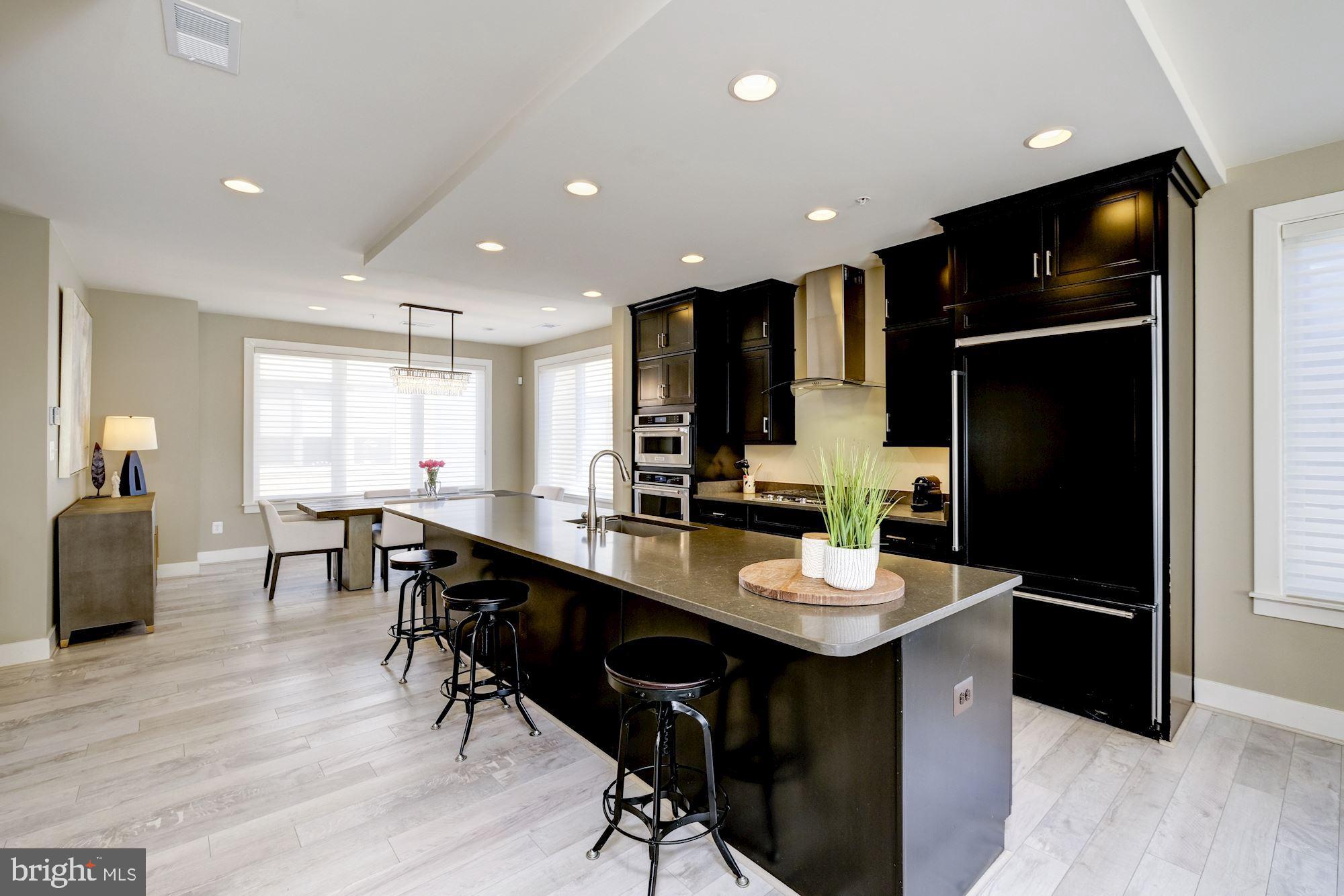 6640 Eames Way Bethesda, MD 20817 - Photo 5 of 38 a kitchen with stainless steel appliances kitchen island granite countertop a table chairs and a refrigerator