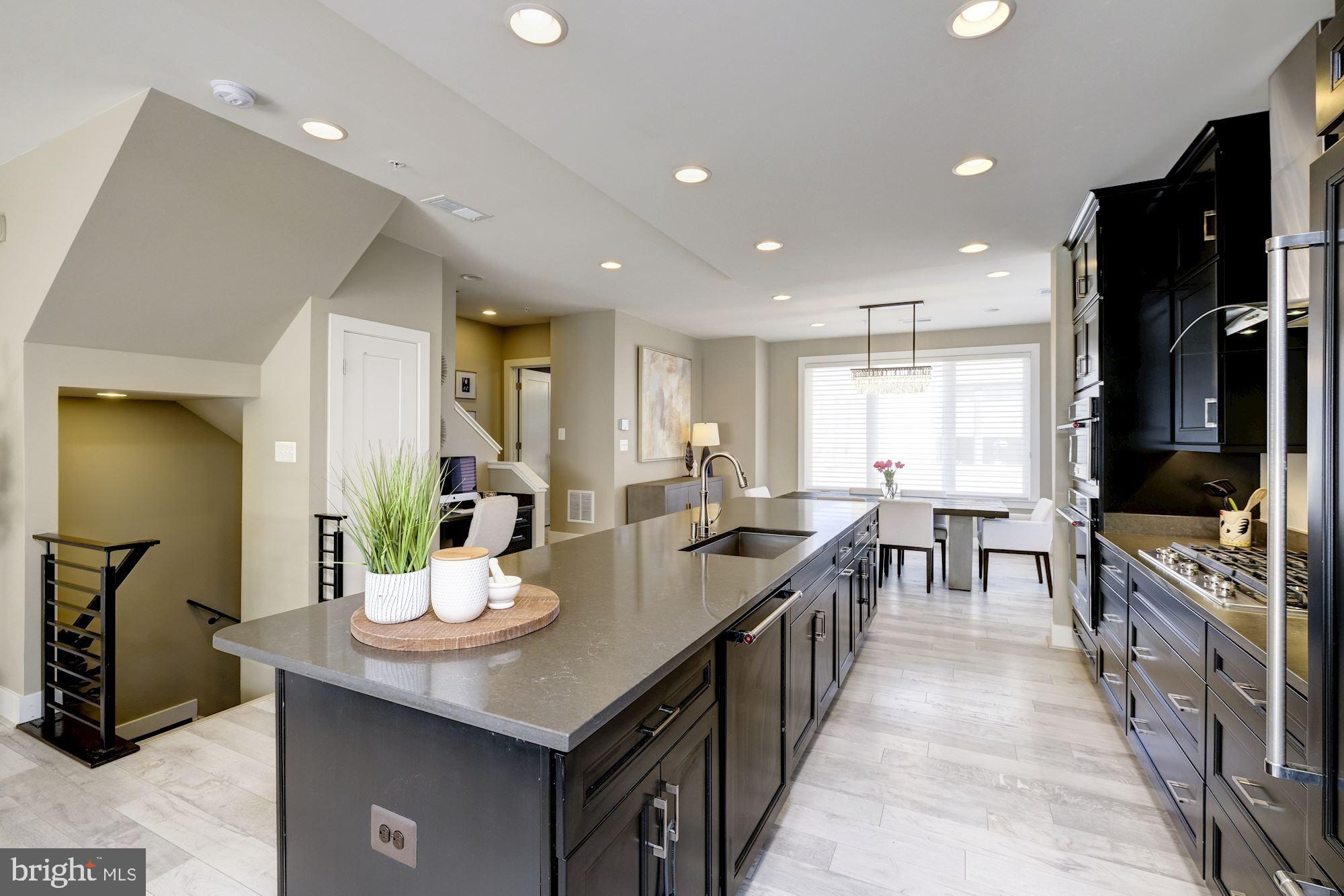 6640 Eames Way Bethesda, MD 20817 - Photo 6 of 38 a kitchen with counter space dining table and chairs