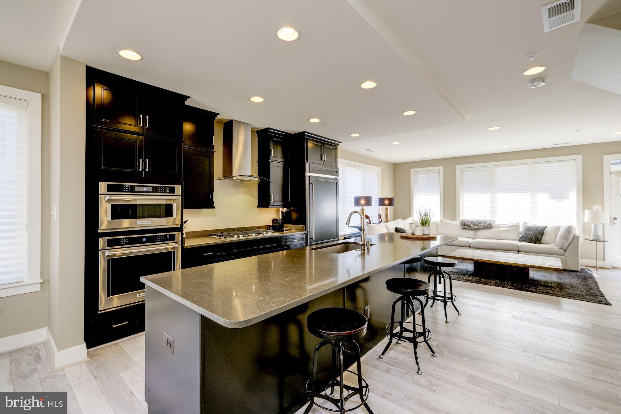 6640 Eames Way Bethesda, MD 20817 - Photo 7 of 38 a kitchen with a table chairs refrigerator and microwave