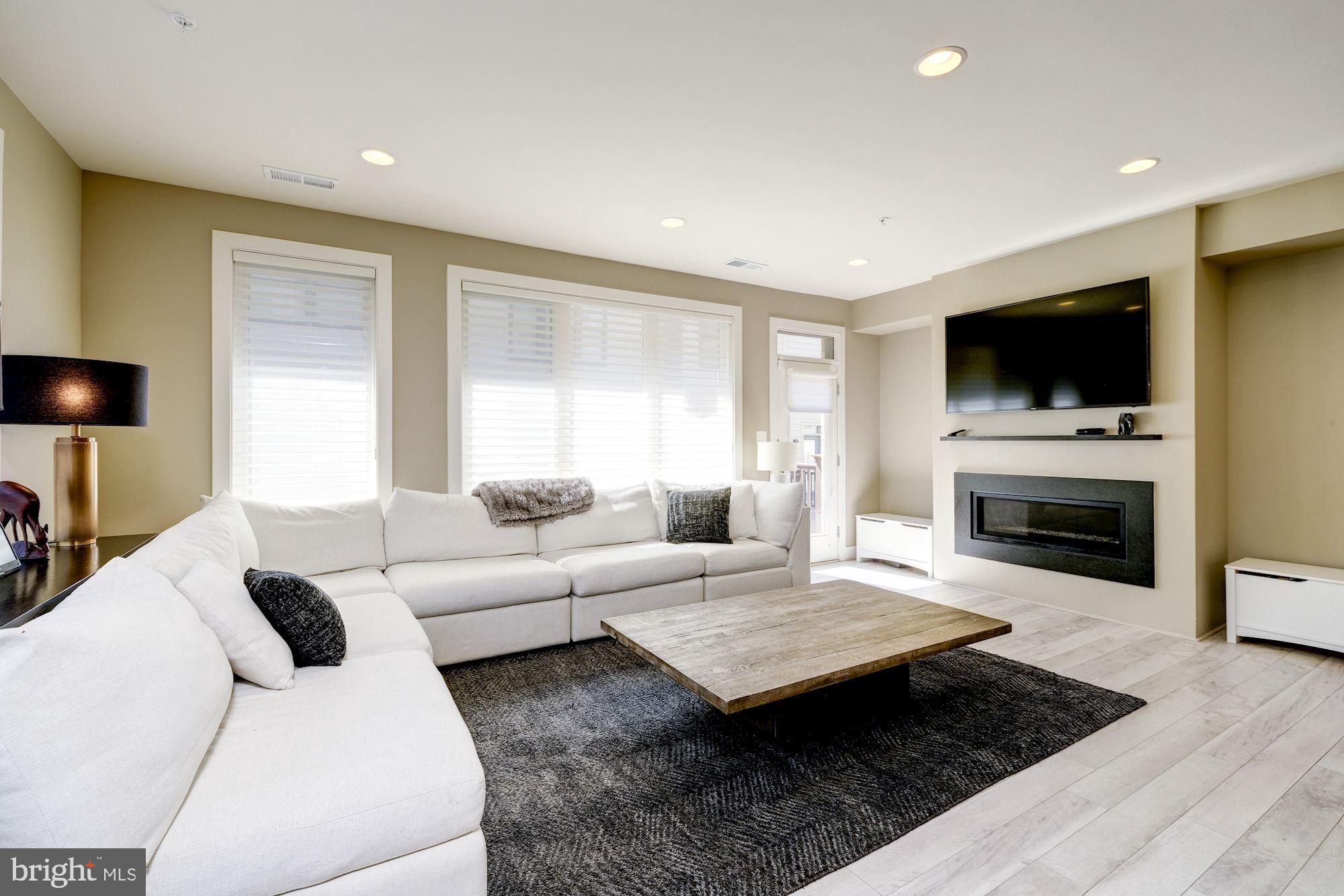 6640 Eames Way Bethesda, MD 20817 - Photo 9 of 38 a living room with furniture a flat screen tv and a fireplace