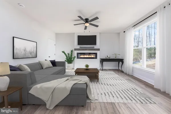 a living room with furniture a flat screen tv and a window