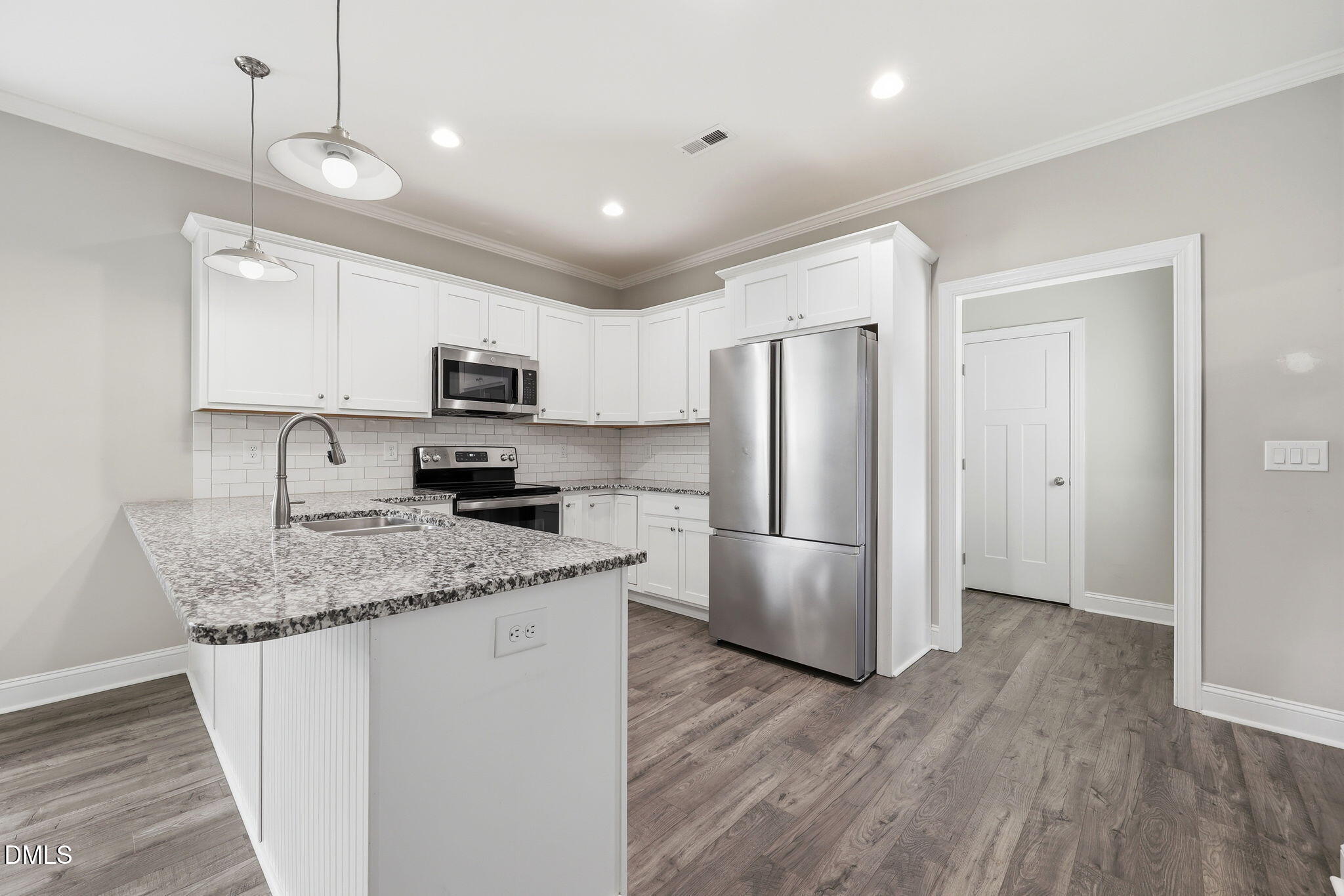 709 South Pollock Street Selma, NC 27576 - Photo 14 of 30 a kitchen with stainless steel appliances granite countertop a refrigerator a sink a stove a microwave and wooden floor