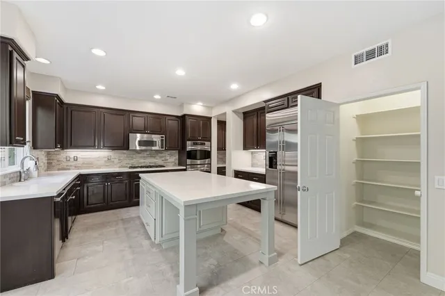 a kitchen with a sink and chairs