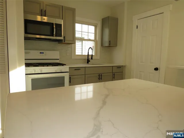 a kitchen with stainless steel appliances a stove top oven and sink
