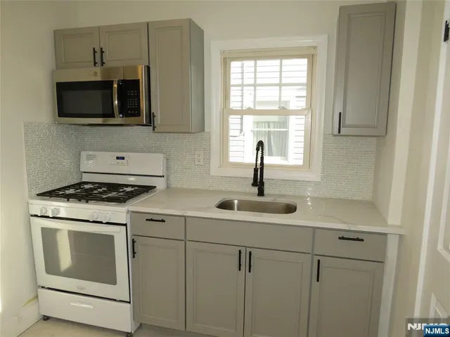 a kitchen with stainless steel appliances granite countertop a sink and a stove
