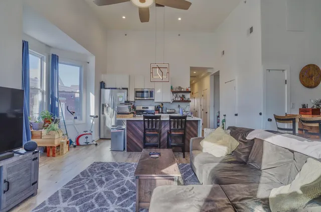 a living room with furniture a rug and kitchen view