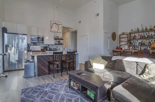 a living room with lots of furniture and kitchen view