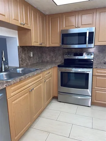 a kitchen with stainless steel appliances granite countertop a refrigerator and a stove top oven